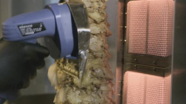 Carne asada rotando mientras es cortada con un cortados electrico