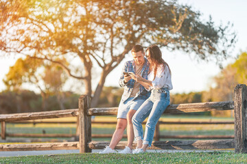Family of two in the park on summer day using smartphone