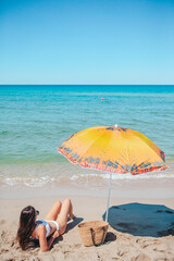 Young beautiful woman relaxing at white sand tropical beach 