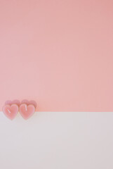 Valentine's day.Two pink candles -hearts  on pastel pink and white background.Flat lay with copy space.Minimal love, romance concept.