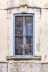 Fototapeta na wymiar A blue framed window on an old building.
