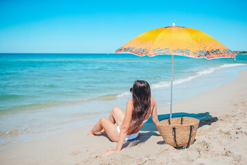 Young beautiful woman relaxing at white sand tropical beach 