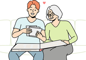 Elderly woman and her son are looking at old photos.