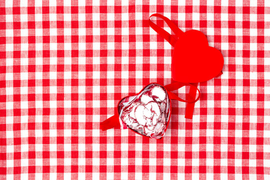 red box in the shape of a heart with cookies for valentine's day on a red checkerd tablecloth
