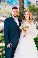 beautiful and happy bride and groom with a bouquet in the park. 