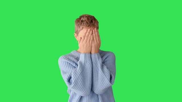 Woman feel panic and fear. Closing face with  hands . green screen.