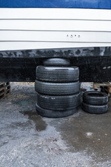Stack of old tires supporting a boat on land.