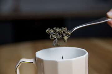 adding green tea to the cup