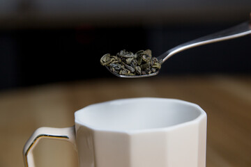 adding green tea to the cup