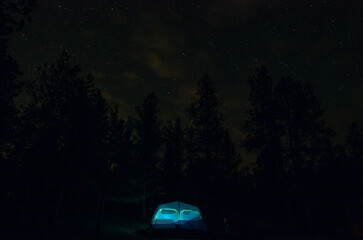 Fototapeta na wymiar Starry night sky over lantern-lit tent