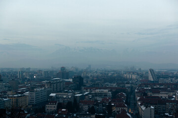 City covered in snow with the mountains in the background