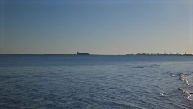 Sunrise over Sea with People Walking Dogs on Semaphore Beach during Winter Morning