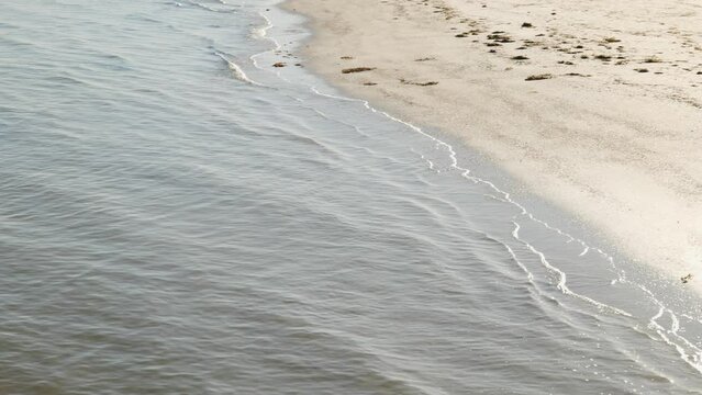 Small Waves Roll on Bright White Sand