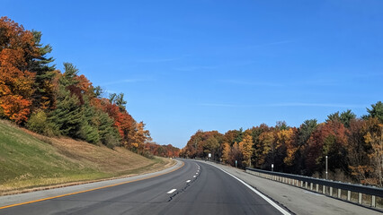 Winding highway with colorful foliage in the fall, Upstate NY, USA