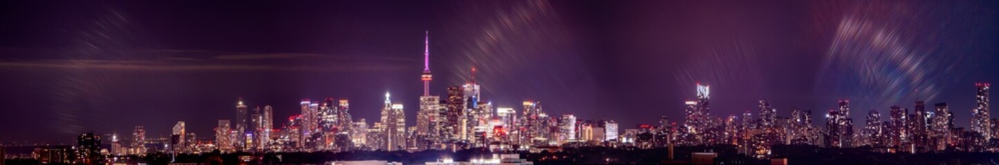 Fototapeta na wymiar Toronto skyline at night with buildings street lights. Toronto, Ontario, Canada. Down town city skyline and panorama with urban areas. Sky with lights leaks.