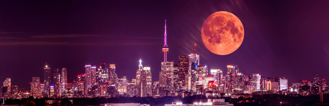 Full moon over Toronto at night. Toronto, Ontario, Canada skyline and moonlight of full moon. Cityscape with rising moon over GTA center. Great Toronto Area night city view.