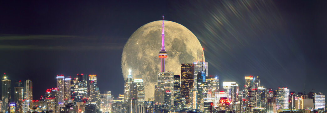 Full moon over Toronto at night. Toronto, Ontario, Canada skyline and moonlight of full moon. Cityscape with rising moon over GTA center. Great Toronto Area night city view.