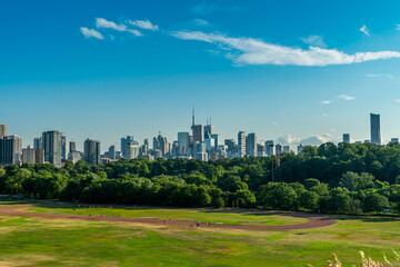 Fototapeta na wymiar Toronto skyline at warm summer. Toronto, Ontario, Canada. Panoramic view of Toronto skyline near Ontario lake at sunset at scattered clouds.