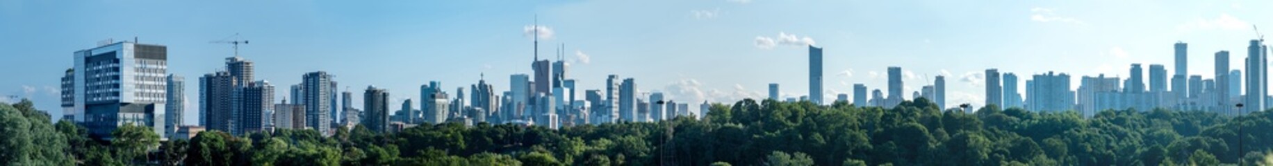 Toronto skyline at warm summer. Toronto, Ontario, Canada. Panoramic view of Toronto skyline near Ontario lake at sunset at scattered clouds.