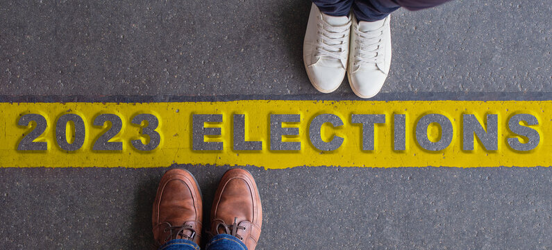 2023 Elections Illustration. Two People Facing Each Other, Divided By A Yellow Line. Top View, Copy Space.