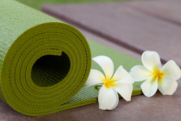 green yoga mat and a flower outdoor, healthy and sport concept - Powered by Adobe