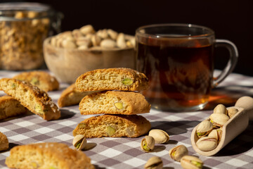 Biscotti Cantuccini Cookie Biscuits with pistachios and lemon peel Shortbread. Cup of tea. Teatime break Healthy eating food. Homemade fresh Italian cookies cantucci stacks and organic pistachios nuts