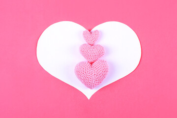 Croched pink hearts on a pink background. Valentine's Day, symbol of love.