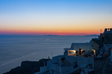 Fototapeta premium Twilight hour over Santorini, overlooking the caldera, under a dramatic sky, Oia Village, Greece