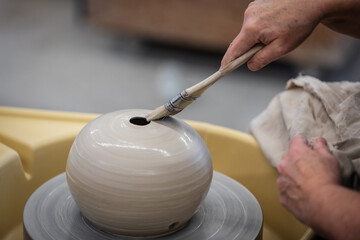 Glazing Raku Pottery with a brush on a spinning throw wheel