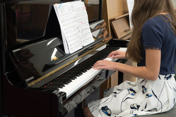 teenage girl playing the piano in the classroom, music hobby