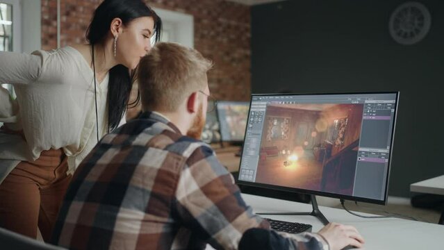 game developer and designer discussing new interface in office, male and female coworkers