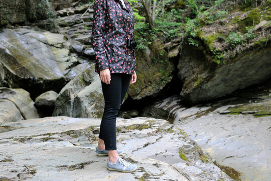 Low section of woman standing on rock in forest