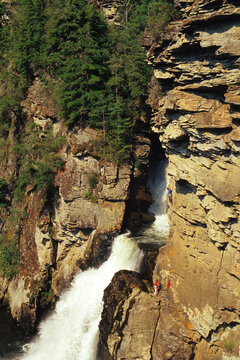 Male Climber ascends a face next to a waterfall in Linville Gorge, NC