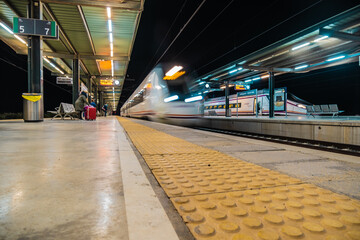 View of tracks and trains at the train station in Ronda at night
