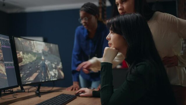 female game designer, supervisor and developer are discussing new project, looking at display