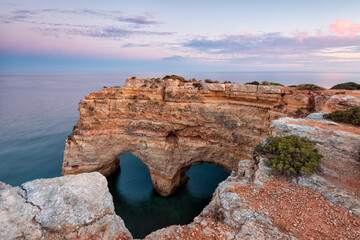 Nature celebrates Valentines Day with the symbol of love carved by nature. Algarve, Portugal.  Seascape of romantic scenario. Heart shaped on rock in amazing beach.