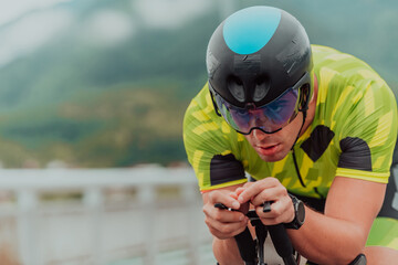 Close up photo of an active triathlete in sportswear and with a protective helmet riding a bicycle....