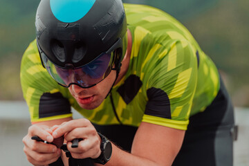 Close up photo of an active triathlete in sportswear and with a protective helmet riding a bicycle....
