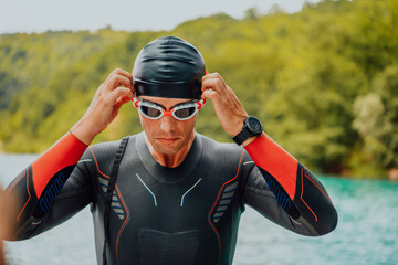 Athlete putting on a swimming suit and preparing for triathlon swimming and training in the river...