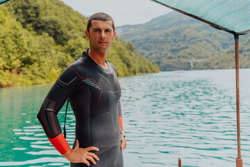 Athlete putting on a swimming suit and preparing for triathlon swimming and training in the river...