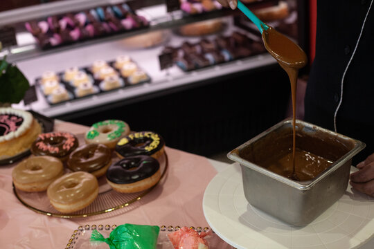 Repostera adornando con letras de colores las donas y rosquillas