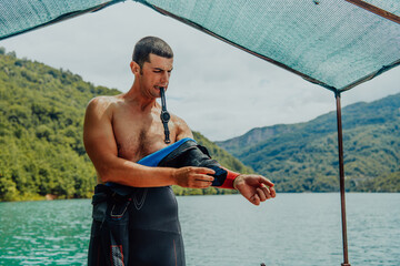 Athlete putting on a swimming suit and preparing for triathlon swimming and training in the river...