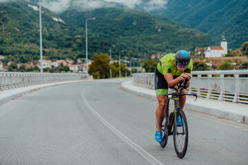 Full length portrait of an active triathlete in sportswear and with a protective helmet riding a bicycle. Selective focus 