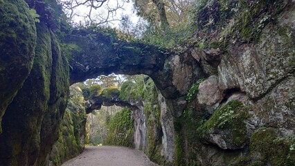 A stone bridge over a path in the mountains