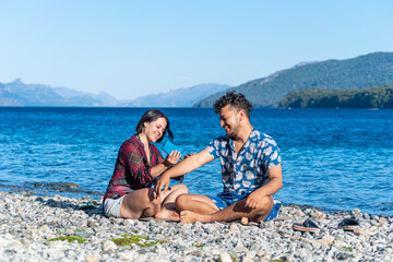 pareja en la playa de vacaciones tomando sol cerca de una laguna 