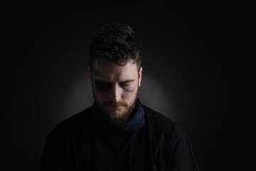 Man with bruise on dark background. Hostage