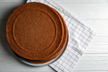 Delicious homemade sponge cakes on white wooden table, top view