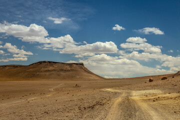 Fototapeta na wymiar Dirt road in Moon Valley dramatic landscape at Sunset, Atacama Desert, Chile