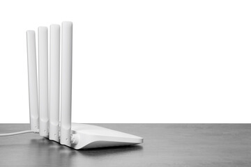 New modern Wi-Fi router on grey table against white background. Space for text