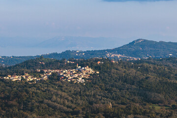 Fototapeta premium Corfu island view from Kaiser's Throne observation deck lookout, Pelekas village, Greece, Kaiser William II summit Observatory panoramic summer view with mountains, sea and Kerkyra in a background